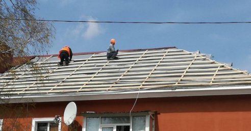 Коммунальщики ремонтируют поврежденные обстрелами окна и кровли